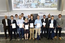 Eine Gruppe von acht jungen Männern und einer Frau, gekleidet in Anzug und Kleid, halten stolz ihre Masterzeugnisse. Umrahmt werden diese von zwei Professoren, Herrn Prof. Dr. Peter Felfer und Herrn Prof. Dr. Kyle G. Webber.